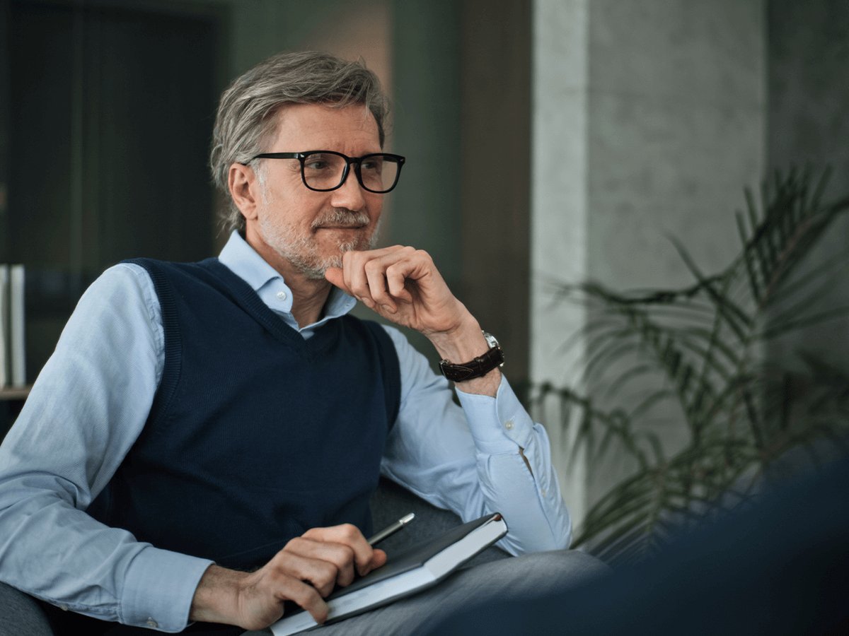 A man smiling in a thoughtful pose