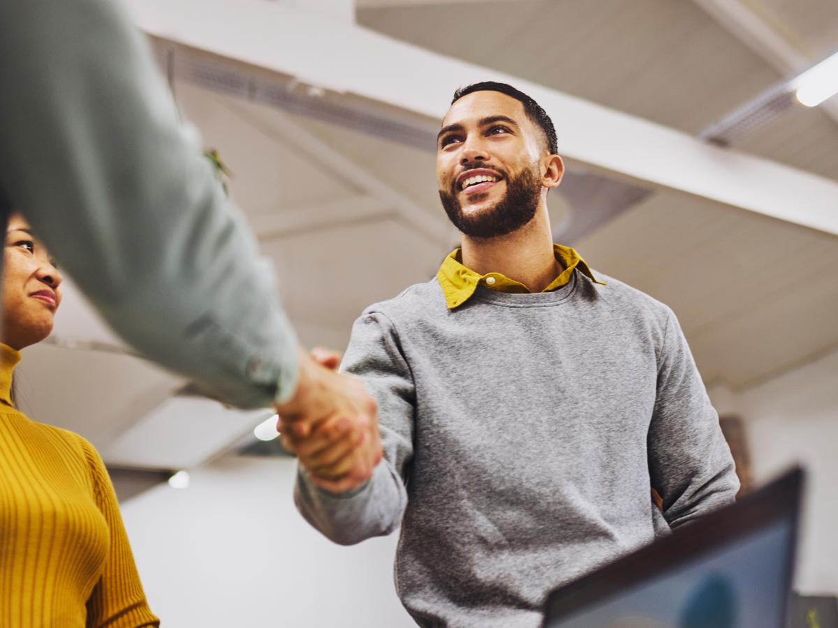 Male business student shaking someone's hand.