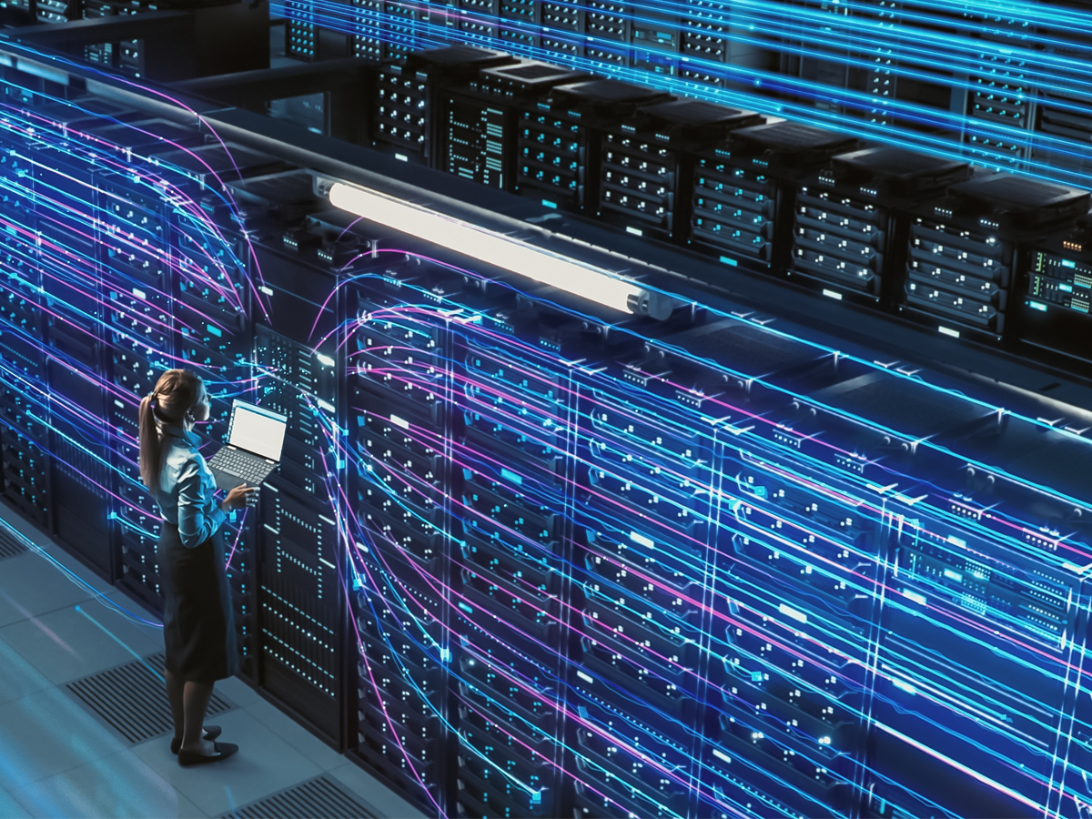 Woman standing in front of computer at a data center
