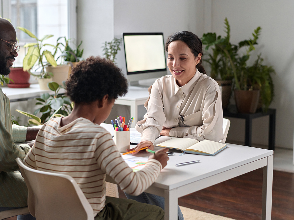 Lady pointing things out to a child while the man next to them Smiles proudly