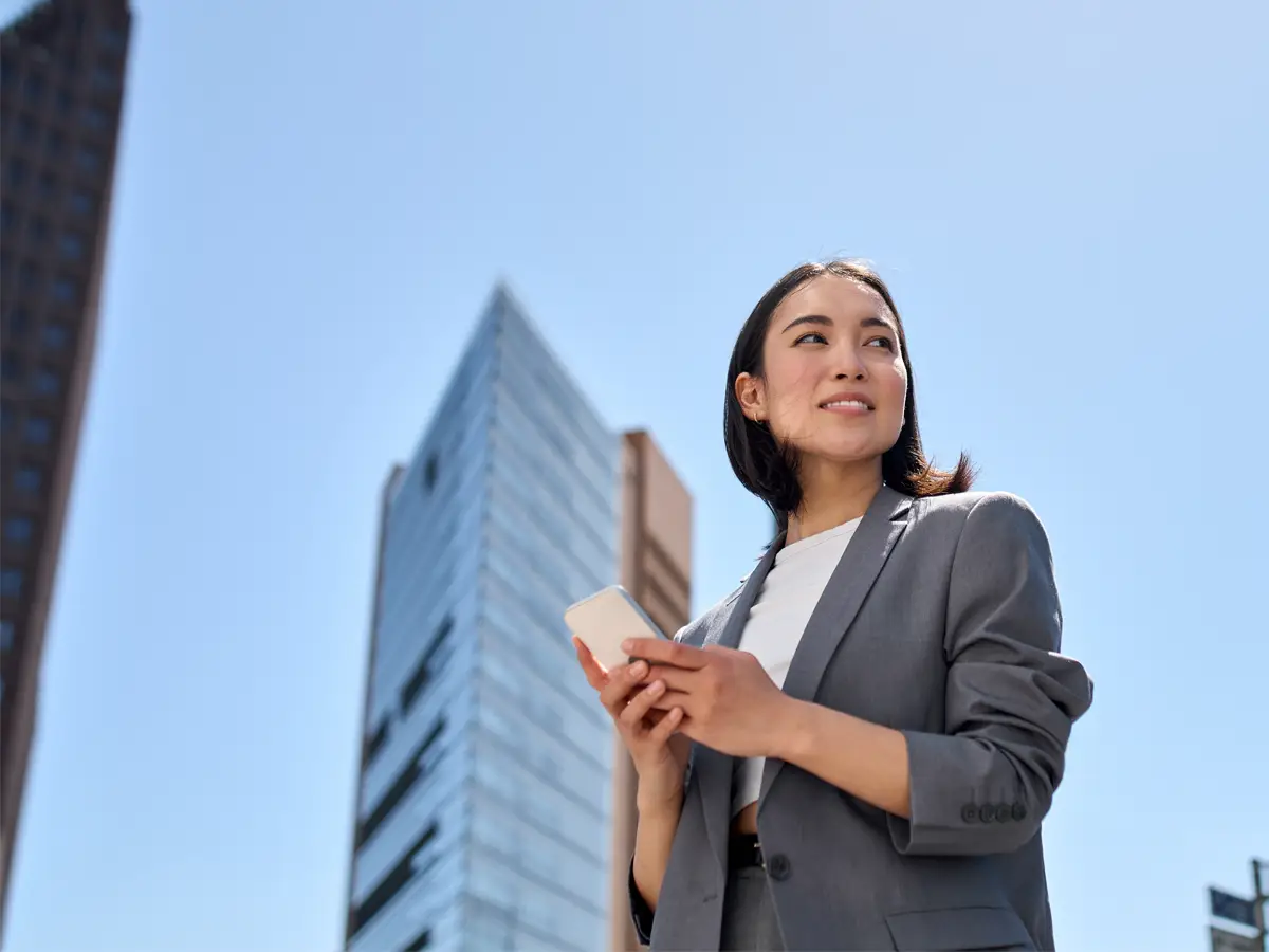 young busy successful woman holding her phone but looking elsewhere