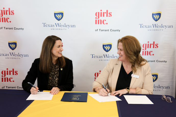 Dr Messer and a representative from Girls Inc Tarrant County sign an MOU