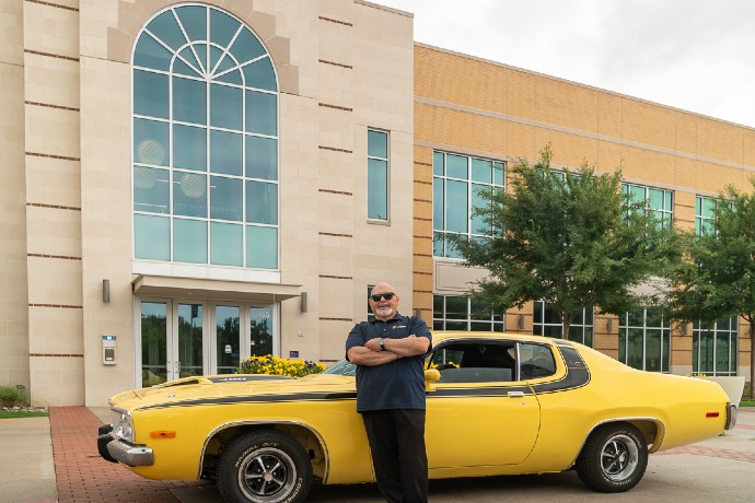 Ric Rodriguez leans on his car in front of the Martin Center