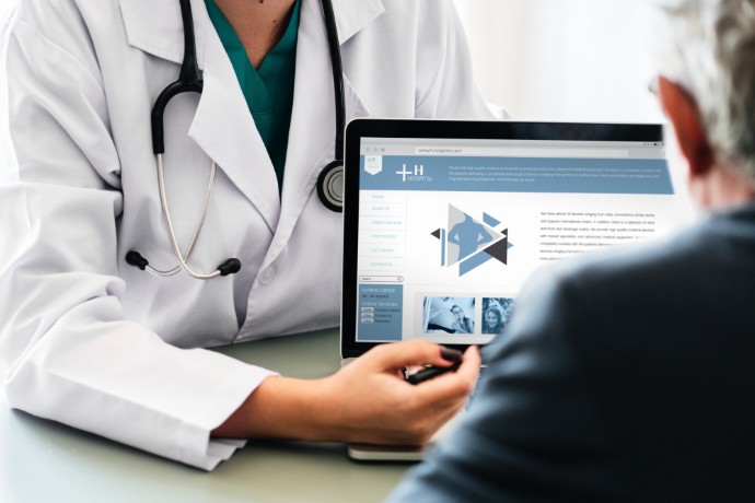 picture of doctor showing patient information on computer