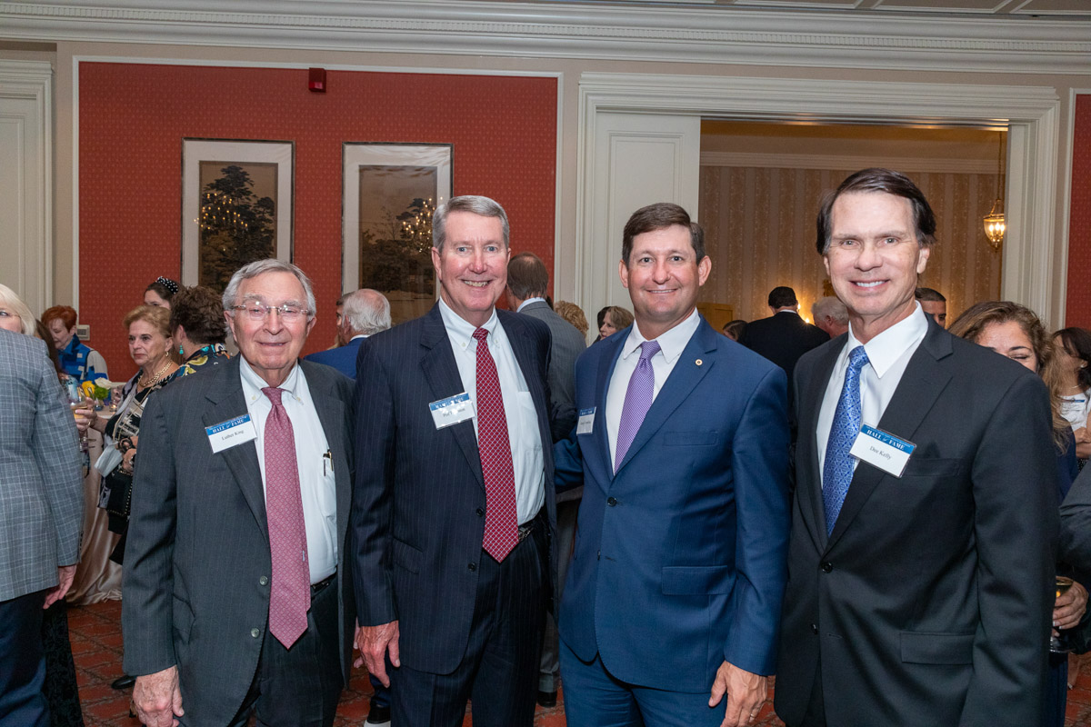 four business men pose for a portrait