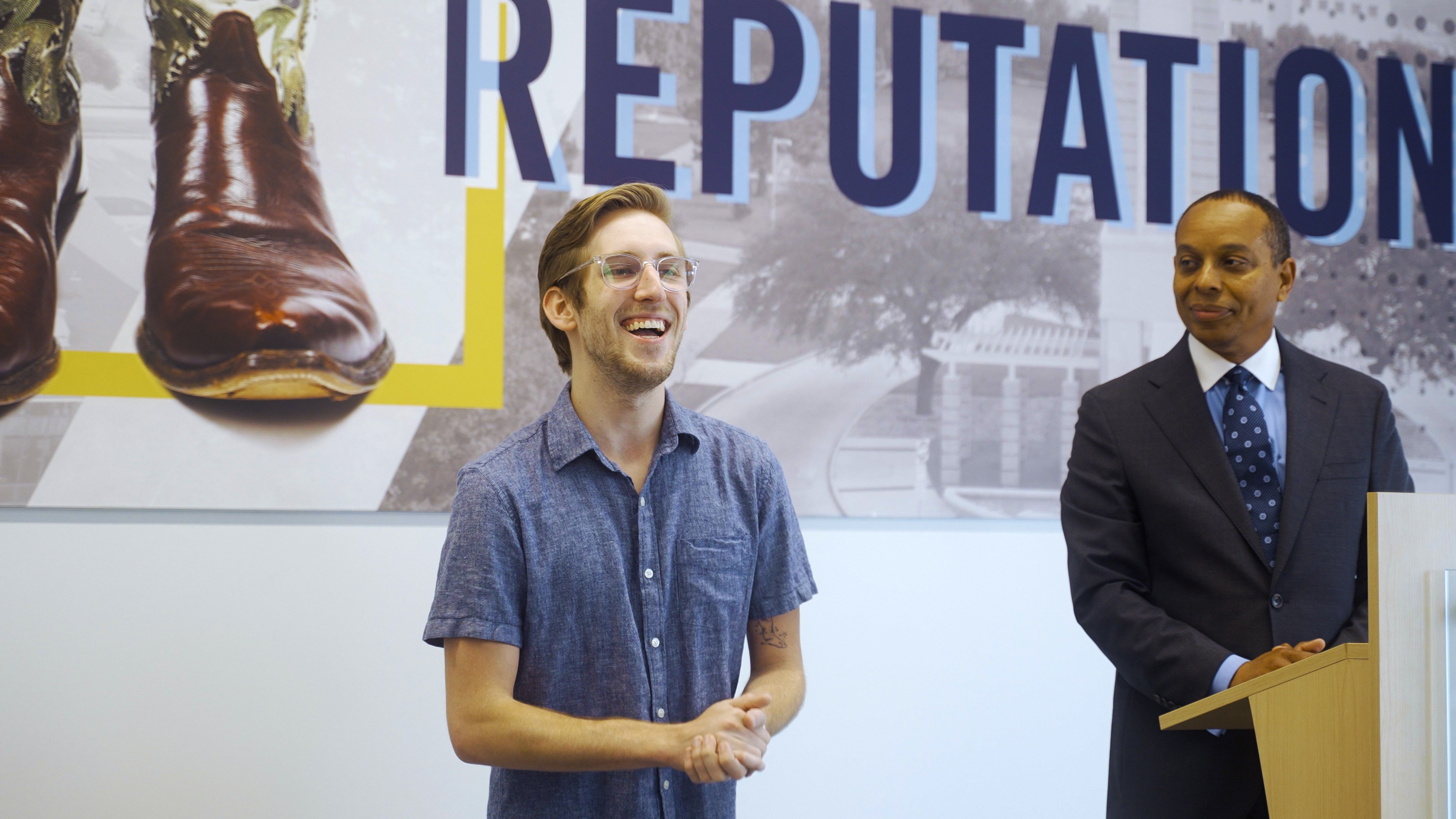 person standing in front of a banner with the words reputation