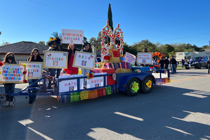 Students and faculty from the School of Arts and Sciences posing on their float for the Fort Worth Dia de los Muertos Parade