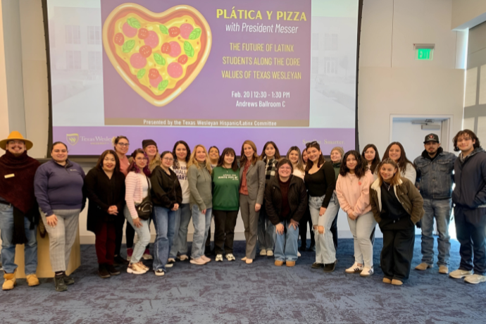 Latinx students eat pizza with Dr. Messer while discussing core values.