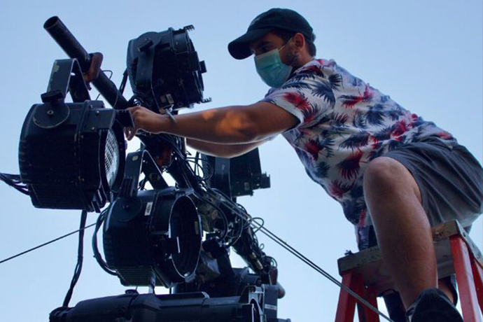 A man adjusting a cinema camera