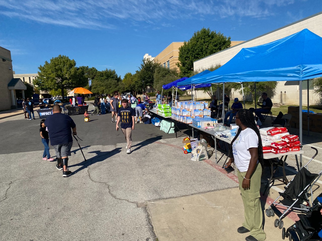 People gathered around tables for clothing give-away.