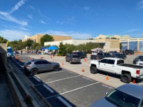 Line of cars waiting to receive free groceries.