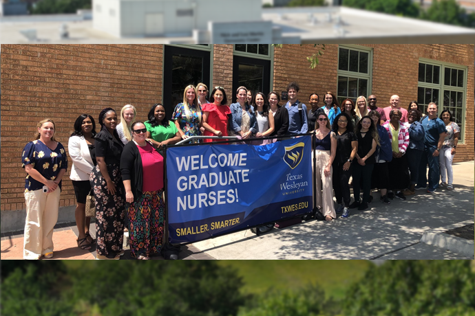 The 2023 fall cohort of DNP and FNP nursing students pose with a banner welcoming them to campus