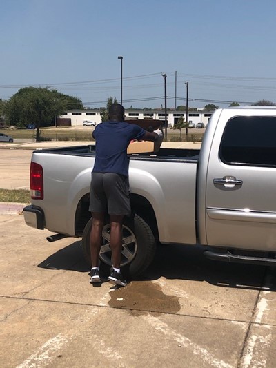 Photo of basketball team putting food into pickup truck at Contreras Elementary.
