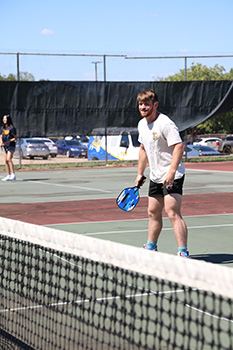 Zeb Fulmer, President of Pickleball Club, playing pickleball on the pickleball court