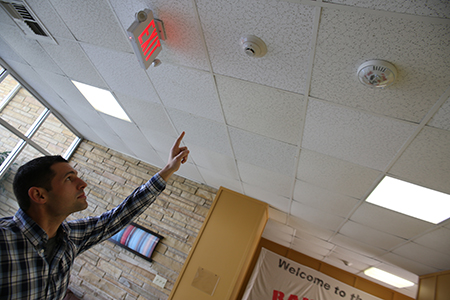 Brian Franks points to fire monitoring system in Stella Hall